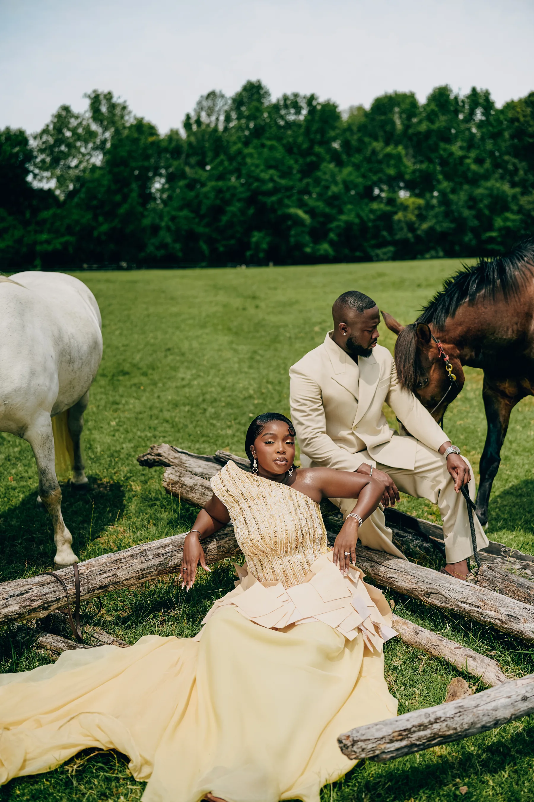 Samanta seated against fallen logs while Ryan sits beside a horse